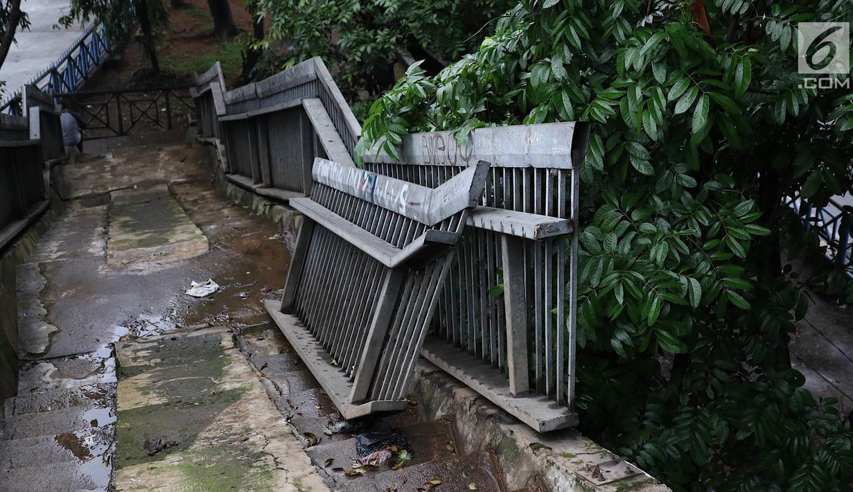Suasana jembatan penyeberangan orang yang rusak di Terminal Kampung Rambutan, Jakarta, Senin (28/1). Kondisi JPO yang sebagian pagar pembatasnya rusak tersebut membahayakan pejalan kaki apabila tidak segera diperbaiki. Liputan6.com/Immanuel Antonius