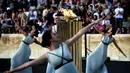 Para penari beraksi di sekitar koldron api olimpiade dalam sebuah upacara penyerahan kepada panitia Olimpiade Rio di Stadion Panathinean, Athena, Yunani, (27/4/2016). (AFP/Aris Messinis)