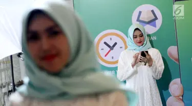 Model melihat aplikasi muslim berbasis komunitas bernama "umma", Jakarta, Kamis (25/4). Aplikasi dengan fitur penunjang ibadah, konten islami yang dipersonalisasi kecerdasan buatan dan fitur komunitas memiliki misi untuk mempermudah umat muslim Indonesia menjadi khairu ummah. (Liputan6.com/HO/Ading)