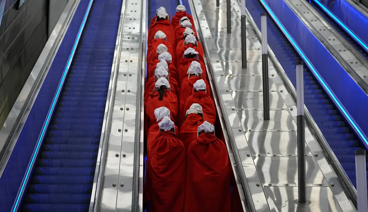 Pengunjuk rasa yang mendukung hak-hak perempuan berpakaian seperti karakter dari serial TV "The Handmaid's Tale" saat melakukan perjalanan untuk memprotes rencana pemerintah baru Perdana Menteri Benjamin Netanyahu untuk merombak sistem peradilan di sebuah stasiun kereta api di Yerusalem, Israel, 1 Maret 2023. Mengacu pada fenomena yang berkembang, harian Inggris The Guardian menggambarkan penampilan para pelayan sebagai salah satu simbol paling kuat dari protes feminis kontemporer. (AP Photo/Ohad Zwigenberg)