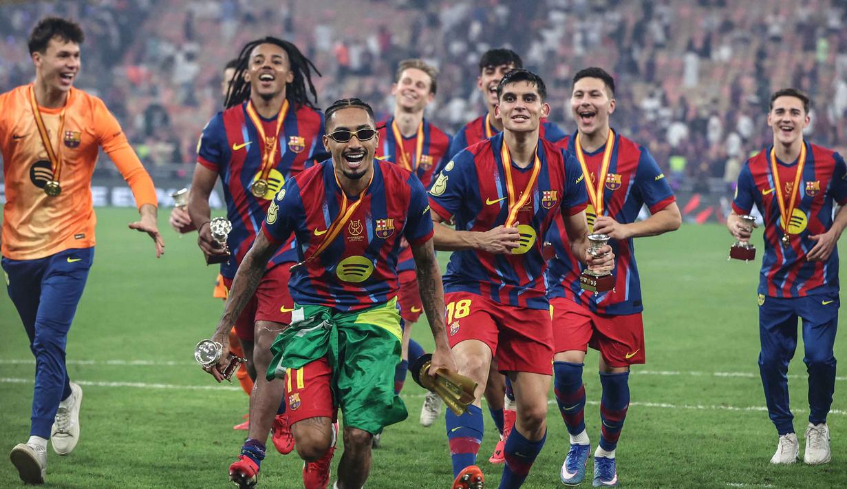 Gol penentu kemenangan Barcelona tercipta pada menit ke-73 lewat aksi Raphinha. Skor tidak berubah hingga menit akhir pertandingan. Tampak dalam foto, penyerang Barcelona asal Brasil, Raphinha merayakan kemenangan bersama rekan-rekan setimnya usai pertandingan final Piala Super Spanyol melawan Real Madrid di King Abdullah Sports City Stadium, Jeddah pada Minggu 11 Januari 2026 waktu setempat atau Senin 12 Januari 2026 dini hari WIB. (Fadel SENNA/AFP)