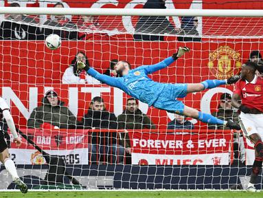 Kiper Manchester United, David de Gea, berusaha menghalau bola saat melawan Fulham pada laga Liga Inggris di Stadion Old Trafford (19/3/2023). (AFP/Paul Ellis)