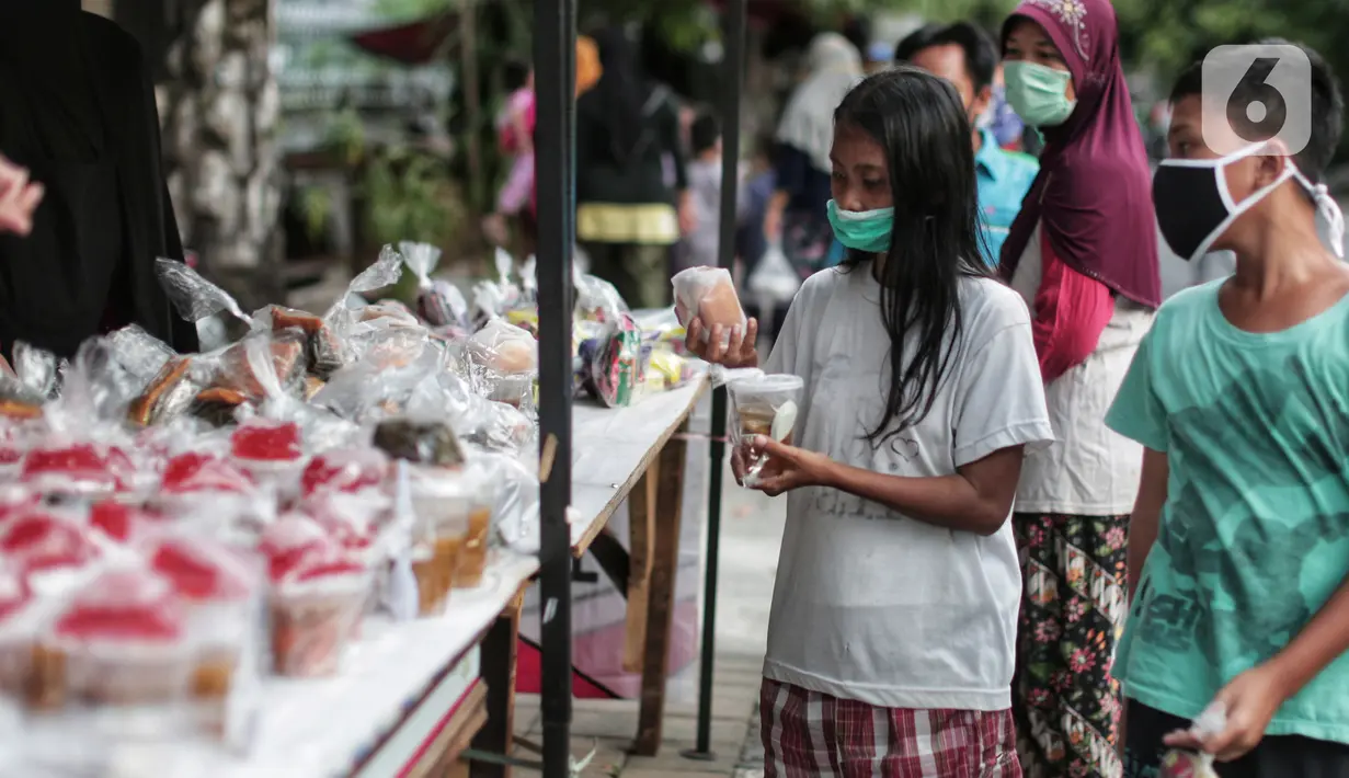 Warga mengambil takjil yang dibagikan di Jalan Cempaka Putih Raya, Jakarta, Senin (11/5/2020). Setiap hari selama Ramadan, masyarakat sekitar membagikan 350 takjil kepada warga kurang mampu dan terdampak virus corona COVID-19. (Liputan6.com/Johan Tallo)