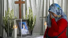 Seorang ibu mengusap air mata di depan peti mati korban bom Surabaya Sri Puji, Surabaya, Jawa Timur, Senin (14/5). Sri Puji menjadi korban meninggal dalam serangan di Gereja Pantekosta. (AFP PHOTO/JUNI KRISWANTO)