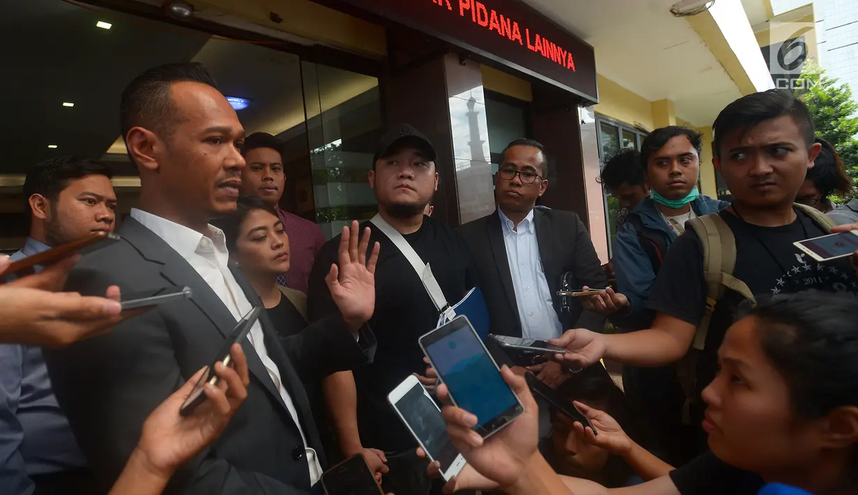 Pelapor penganiayaan, Ronny Yuniarto (tengah) bersama istri dan kuasa hukumnya, Febby Sagita (kiri) saat menjawab pertanyaan wartawan usai membuat laporan di Polres Metro Jakarta Selatan, Kamis (21/6). (Merdeka.com/Imam Buhori)