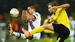 Bek Dortmund, Marcel Schmelzer, berebut bola dengan gelandang Tottenham, Erik Lamela. Pada laga itu Dortmund lebih menguasai jalannya pertandingan dengan penguasaan bola 65 persen. (AFP/Patrik Stollarz)
