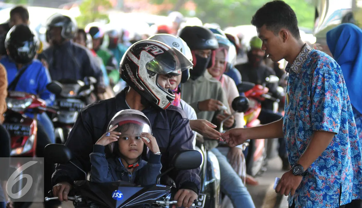 Petugas mengecek tiket masuk di pintu Utama untuk memasuki Taman Impian Jaya Ancol, Jakarta Utara, Jumat (6/5). Libur panjang dimanfaatkan warga Jakarta untuk mengunjungi objek wisata di Kawasan Ancol. (Liputan6.com/Gempur M Surya)