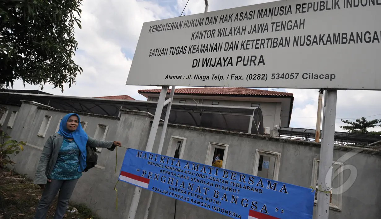 Ecin melakukan aksi dengan membawa spanduk menunjukan di depan dermaga Wijaya Pura, Cilacap, Jawa Tengah, Minggu (8/3/2015). Ecin mengharapkan agar pemerintah mempercepat eksekusi mati terpidana narkoba. (Liputan6.com/Johan Tallo)