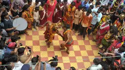 Sejumlah seniman menari saat festival tradisional 'Bonalu' di Kuil Sri Ujjaini Mahankali, India (10/7). Bonalu adalah sebuah ritual persembahan sebagai tanda syukur kepada dewi Mahakali. (AFP Photo/Noah Seelam)