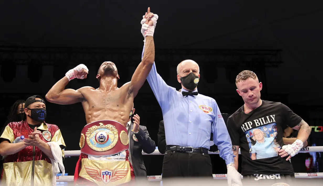 Petinju Amerika Serikat Jamel Herring (kiri) mengangkat tangannya setelah mengalahkan petinju Inggris Carl Frampton pada ronde keenam perebutan gelar dunia kelas bulu super WBO di Dubai, UEA, Minggu (4/4/2021). (AP Photo/Kamran Jebreili)