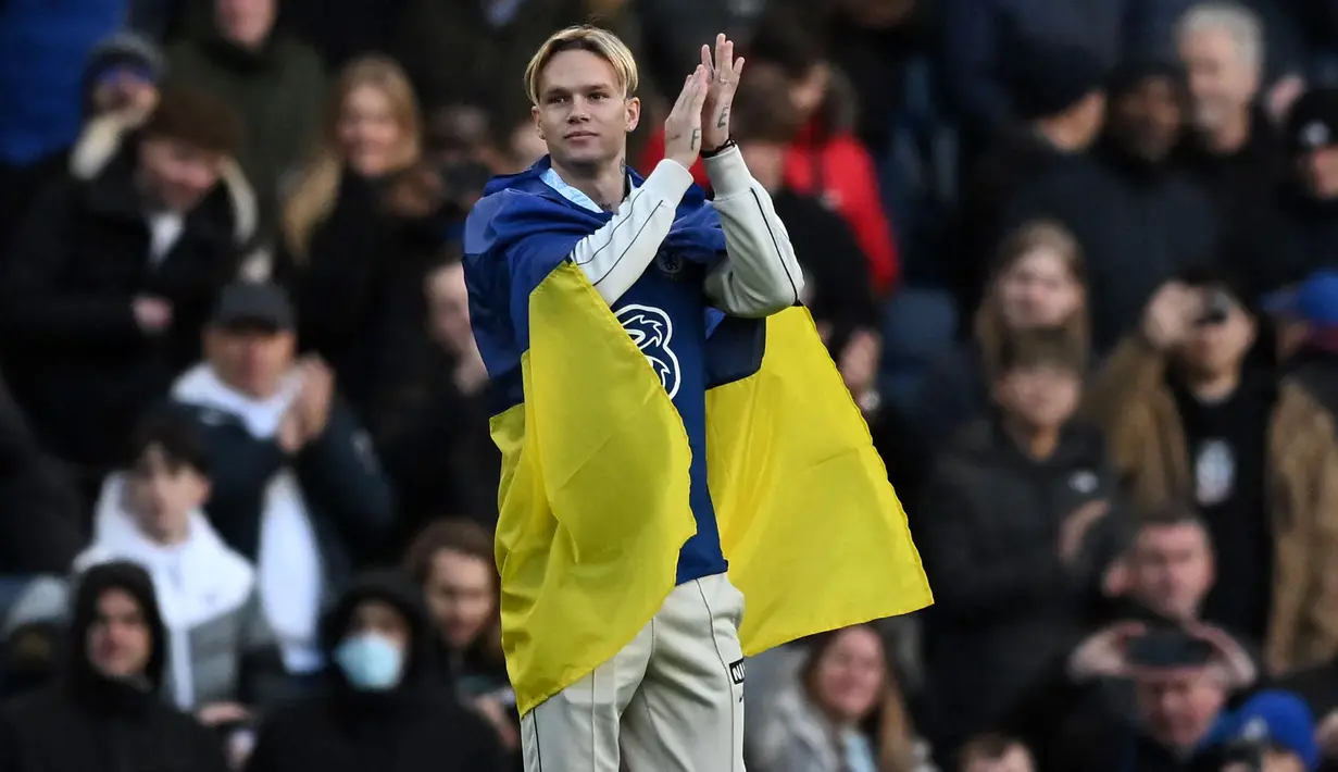 Rekrutan baru Chelsea, Mykhailo Mudryk memperkenalkan dirinya sambil membawa bendera Ukraina saat jeda babak pertama laga lanjutan Liga Inggris 2022/2023 melawan Crystal Palace di Stamford Bridge, London, 15 Januari 2023. Mudryk dibeli Chelsea dari Shakhtar Donetsk dengan harga 70 juta euro pada bursa transfer Januari 2023. (AFP/Ben Stansall)
