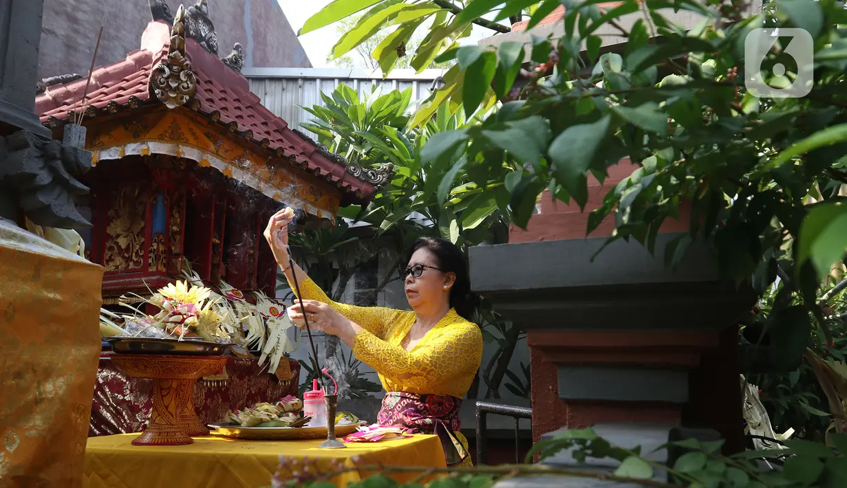 Umat Hindu saat melaksanakan ritual persembahyangan Hari Raya Galungan di Kampung Bali, Bekasi Utara, Bekasi, Jawa Barat, Rabu (16/9/2020). Perayaan hari kemenangan kebenaran (Dharma) atas kejahatan (Adharma) tersebut dilakukan di kediaman masing-masing. (Liputan6.com/Herman Zakharia)