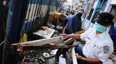 Petugas PT.KAI mengangkat puing di kawasan Stasiun Kemayoran, Jakarta, Senin (9/3/2015).  Pembongkaran sembilan rumah warga yang masih berdiri di kawasan Stasiun kemayoran dilakukan oleh tim gabungan PT KAI. (Liputan6.com/Faizal Fanani)