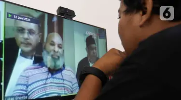 Jurnalis menyaksikan sidang perdana terdakwa kasus pencucian uang, yang juga Gubernur Papua nonaktif Lukas Enembe secara daring di media center Gedung Merah Putih KPK, Jakarta, Senin (12/6/2023). (Liputan6.com/Herman Zakharia)