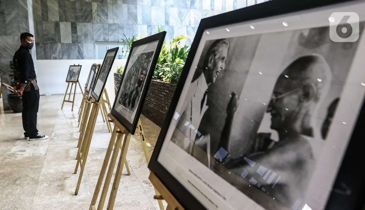 Pengunjung melihat karya lukis dan karya foto pada pameran 150 Tahun Mahatma Gandhi di kompleks Parlemen, Senayan, Jakarta, Jumat (2/10/2020). Dalam pameran ini juga memperingati 150 tahun hari kelahiran Mahatma Gandhi serta Peringatan Hari Anti Kekerasan Dunia. (Liputan6.com/Johan Tallo)