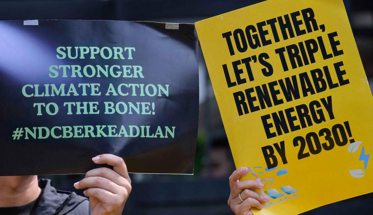 Dalam aksinya, pengunjuk rasa mendesak pemerintah Indonesia menunjukkan komitmen nyata dalam transisi energi yang adil, serta meninggalkan bahan bakar fosil. Tampak dalam foto, aktivis lingkungan menggelar aksi unjuk rasa mendesak pemerintah Indonesia untuk menunjukkan komitmen terhadap transisi dari bahan bakar fosil di depan kantor Kementerian Energi dan Sumber Daya Mineral (ESDM), Jakarta, Rabu 22 April 2026. (BAY ISMOYO/AFP)