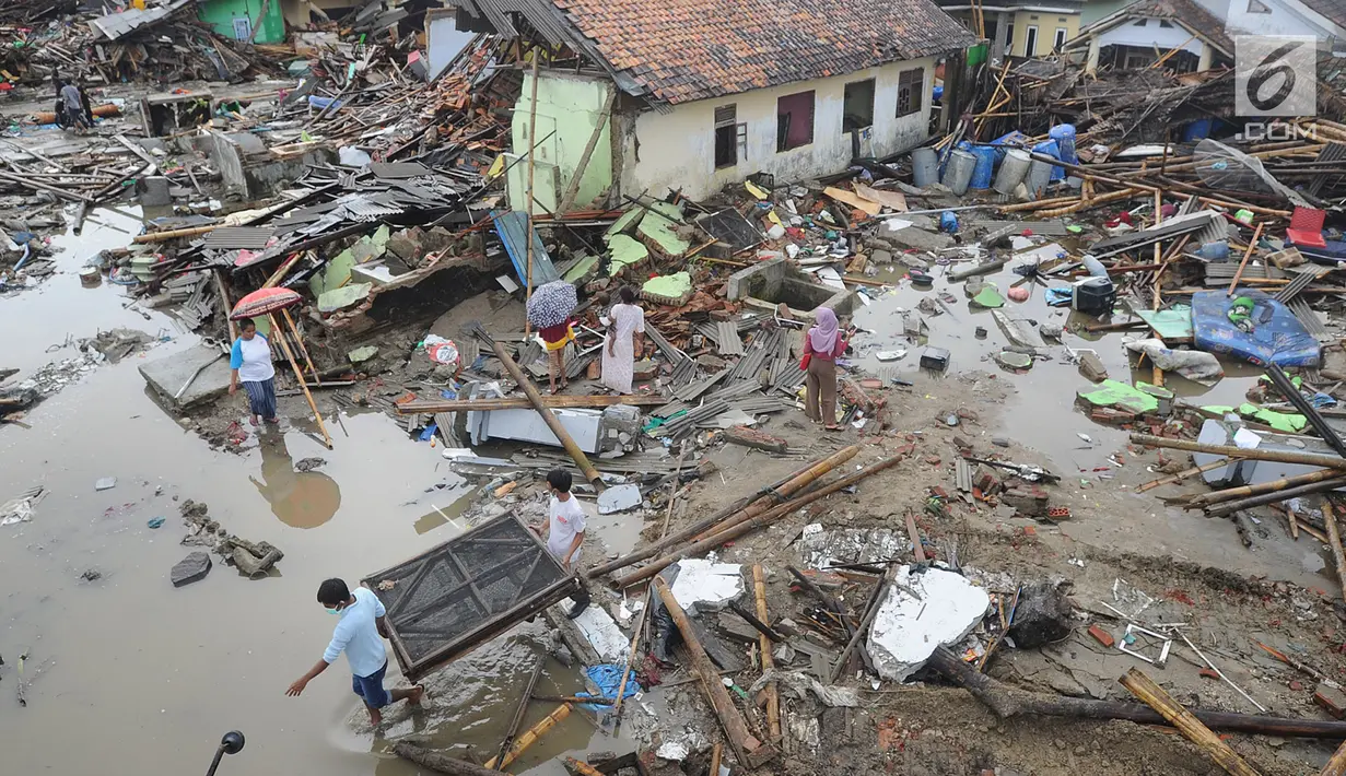 Warga mengumpulkan perkakas dari bangunan rumahnya yang rusak akibat terjangan tsunami di Kampung Sumur Pesisir, Pandeglang, Banten, Senin (24/12). Pascatsunami Selat Sunda, warga pulang untuk mencari  barang berharga miliknya. (Merdeka.com/Arie Basuki)