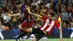 Penyerang Barcelona, Lionel Messi menghindari hadangan pemain Athletic Bilbao, Aymeric Laporte pada laga Piala Super Spanyol di Stadion Camp Nou, Spanyol, Senin (17/8/2015). (AFP Photo/Quique Garcia)