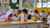 Anak SD di Pekanbaru diwajibkan memakai masker ke sekolah karena kabut asap hasil kebakaran lahan. (Liputan6.com/M Syukur)