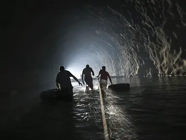 Sejumlah warga menyusuri terowongan saat akan memperbaiki sistem air yang mereka buat di Caracas, Venezuela, Kamis (11/6/2020). Tanpa air minum dari otoritas pemerintah, penduduk Esperanza mengumpulkan air dari dalam terowongan jalan raya Baralt yang tidak pernah selesai. (AP Photo/Matias Delacroix)