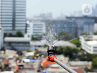 Petugas menyemprotkan air ke udara di Kantor Wali Kota Jakarta Pusat, Selasa (5/9/2023). Alat penyemprot kabut udara (water mist generator) tersebut sebagai langkah untuk mengurangi polusi udara di Jakarta. (Liputan6.com/Herman Zakharia)
