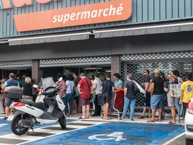 Orang-orang mengantre di luar supermarket di Noumea di tengah protes terkait perdebatan mengenai rancangan undang-undang konstitusi yang bertujuan untuk memperbesar jumlah pemilih untuk pemilu mendatang di wilayah luar negeri Prancis, Kaledonia Baru, Kamis (16/5/2024). (Delphine Mayeur / AFP)