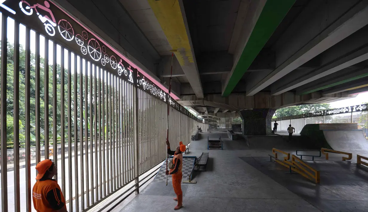Selain arena tinju, terdapat juga fasilitas skatepark berstandar internasional yang dapat digunakan secara gratis. Tampak dalam foto, petugas Penanganan Prasarana dan Sarana Umum (PPSU) melakukan pengecatan di kolong jembatan layang Pasar Rebo, Jakarta Timur, Jumat (8/5/2026). (Kapanlagi.com/Budy Santoso)