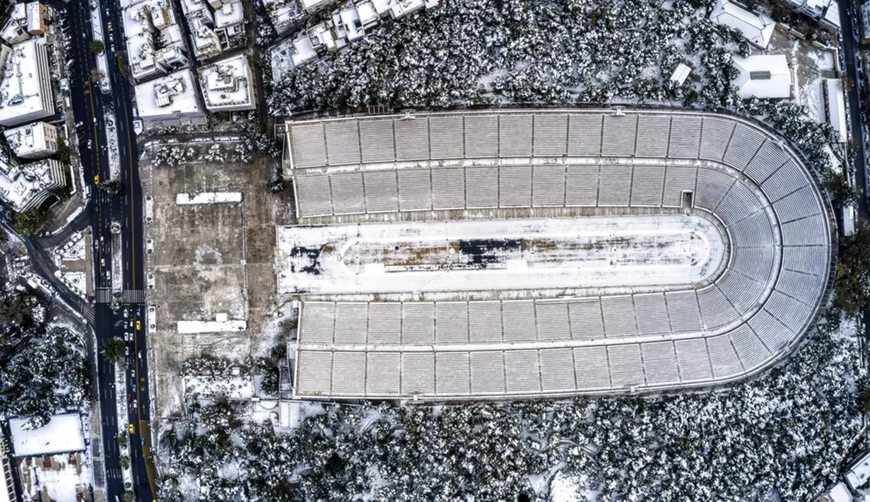 Stadion Panathenian, tempat Olimpiade modern pertama diadakan pada tahun 1896, tertutup salju setelah hujan salju lebat di Athena, Yunani, Rabu (17/2/2021). Salju adalah pemandangan langka di ibu kota Yunani ini. (Antonis Nikolopoulos/Eurokinissi via AP)