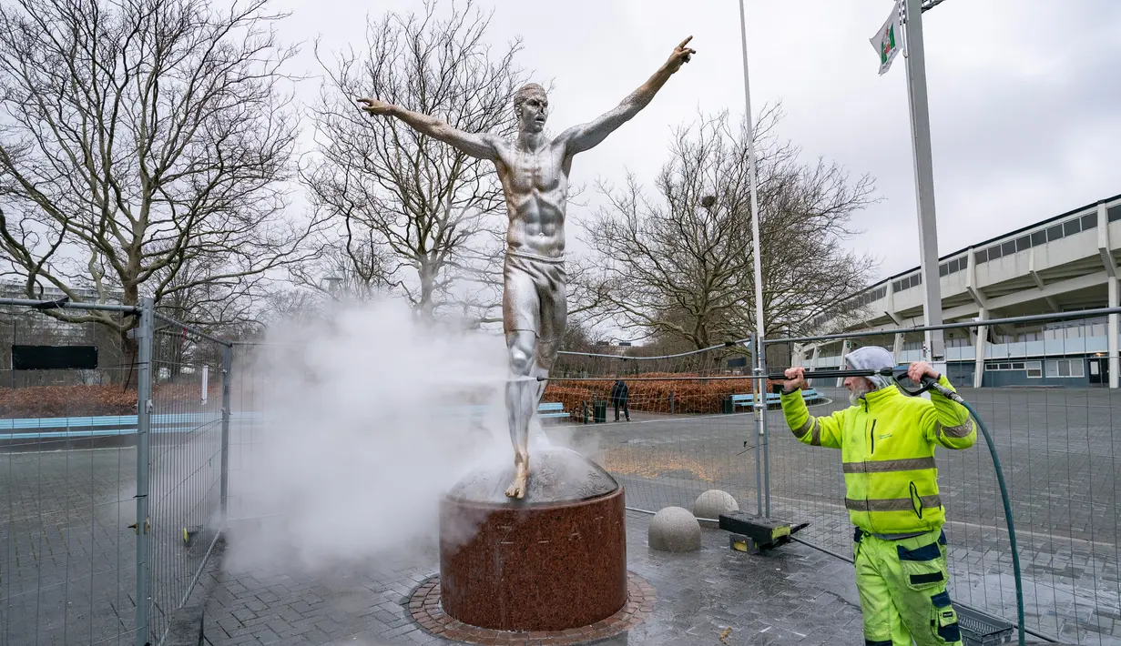 Petugas membersihkan patung Zlatan Ibrahimovic yang rusak, Malmo, Swedia, Minggu (22/12/2019). Perusakan patung yang terjadi untuk kesekian kali tersebut dilakukan fans Malmo karena kecewa sang idola membeli saham di klub rival, Hammarby. (Johan Nilsson/TT News Agency via AP)