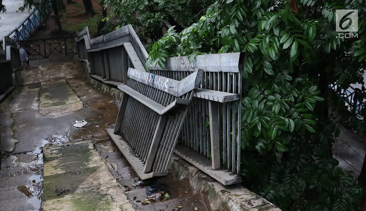 Suasana jembatan penyeberangan orang yang rusak di Terminal Kampung Rambutan, Jakarta, Senin (28/1). Kondisi JPO yang sebagian pagar pembatasnya rusak tersebut membahayakan pejalan kaki apabila tidak segera diperbaiki. Liputan6.com/Immanuel Antonius
