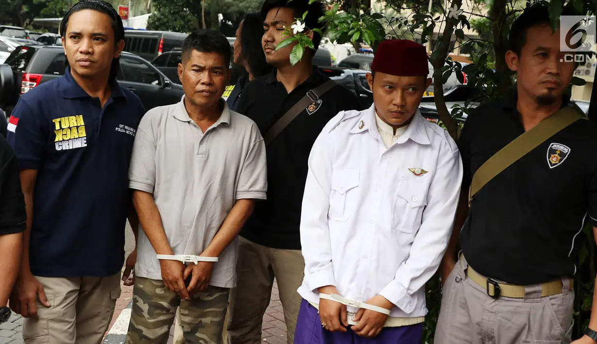 Petugas membawa dua terduga pelaku persekusi U dan M di Polda Metro Jaya, Jakarta, Jumat (2/6). Reskrim Polres Jaktim menangkap dua pelaku persekusi terhadap PMA, 15 tahun, karena diduga menghina FPI dan Rizieq Syihab. (Liputan6.com/Immanuel Antonius)