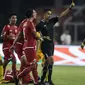 Wasit Thoriq Alkatiri memberikan kartu kuning kepada bek Bhayangkara FC, Sani Rizki, saat melawan Persija Jakarta pada laga Liga 1 di SUGBK, Jakarta, Jumat (23/3/2018). Kedua klub bermain imbang 0-0. (Bola.com/Vitalis Yogi Trisna)