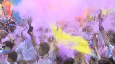 Orang-orang merayakannya di bawah bubuk warna-warni setelah menyelesaikan Colour Run 5 km di Beijing pada 20 April 2024. (JADE GAO/AFP)