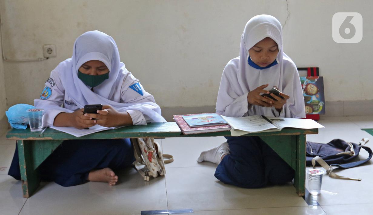 Sejumlah siswa belajar di Aula Kelurahan Jatirahayu, Bekasi, Jawa Barat, Rabu (29/7/2020). Pemerintah Kota Bekasi melalui Kelurahan Jatirahayu menyediakan fasilitas wifi gratis bagi siswa yang terkendala kuota internet dalam kegiatan belajar secara daring. (Liputan6.com/Herman Zakharia)