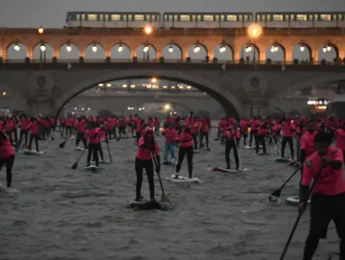 Para peserta ambil bagian dalam perlombaan dayung sambil berdiri pada Nautic SUP Paris di sepanjang sungai Seine, Paris, Prancis, Minggu (3/12). Nautic SUP Paris merupakan lomba dayung sambil berdiri terbesar di dunia. (AFP PHOTO/CHRISTOPHE SIMON)