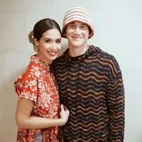 Marsha Timothy terlihat anggun dan menawan dengan kebaya bordir merah yang mewah. Vino pun mendampingi dengan gaya street style dengan bucket dan hoodie yang tetap terlihat serasi. (Foto: Instagram @marshatimothy)