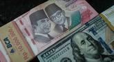 Uang kertas Rp 100.000 diletakkan berdampingan dengan uang dolar Amerika Serikat di salah satu kantor penukaran, Jakarta, Kamis pada 4 Juni 2026. (Yasuyoshi Chiba/AFP)