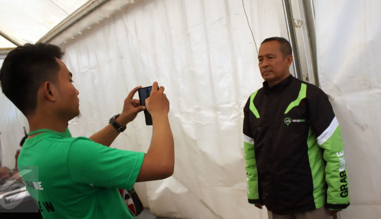 Seorang pelamar melakukan sesi foto saat mendaftarkan diri sebagai pengojek GrabBike di Senayan, Jakarta, Rabu (12/8/2015). Lowongan kerja sebagai pengojek online tersebut merupakan peluang kerja baru bagi masyarakat. (Liputan6.com/Gempur M Surya)