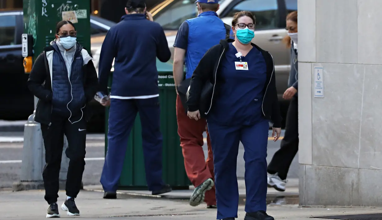 Dua pekerja medis tiba untuk giliran kerja di NewYork-Presbyterian Hospital / Weill Cornell Medical Center selama pandemi COVID-19 di New York City (21/4/2020). (Cindy Ord/Getty Images/AFP)