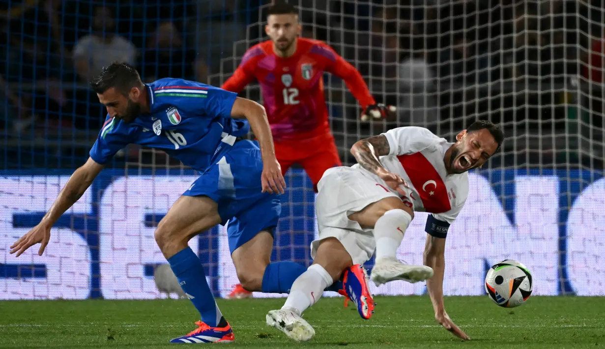 Gelandang Italia #16 Bryan Christante berebut bola dengan gelandang Turki #10 Hakan Calhanoglu (kanan) pada laga uji coba pemanasan Piala Eropa 2024 di Renato dall'Ara, Rabu (5/6/2024) dini hari WIB.  (Alberto PIZZOLI/AFP)