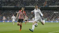 Aksi pemain Real Madrid, Gareth Bale (kanan) mencoba melewati adangan pemain Athletic Bilbao, Unai Nunez pada lanjutan La Liga Santander di Santiago Bernabeu stadium, Madrid, (18/4/2018). Real Madrid bermain imbang 1-1 dengan Bilbao. (AP/Francisco Seco)