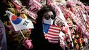 Sepanjang jalan sekitar kantor kepresidenan Korea Selatan di Seoul dipenuhi deretan karangan bunga dikirim oleh para pendukung Yoon Suk Yeol. (Yasuyoshi CHIBA/AFP)