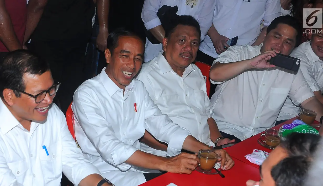 Capres nomor urut 01 Joko Widodo atau Jokowi, Politikus PDIP Pramono Anung, Gubernur Sulut Olly Dondokambey dan Ketua TKN Erick Thohir saat ngopi di Jalan Roda, Manado, Minggu (31/3). Sebelum menikmati kopi jokowi hadiri acara silaturahmi pengurus KGM dan PGI. (Liputan6.com/Angga Yuniar)