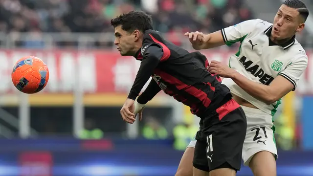 Christian Pulisic (kiri) berduel dengan Jay Idzes di laga AC Milan vs Sassuolo di pekan ke-15 Serie A 2025/2026 di San Siro, Minggu (14/12/2025). (AP Photo/Luca Bruno)