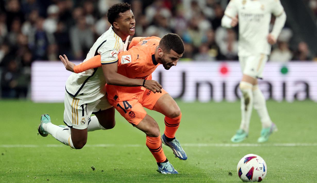 Pemain Real Madrid, Rodrygo berusaha melewati pemain Valencia, Jose Gaya, pada laga Liga Spanyol di Stadion Santiago Bernabeu, Sabtu (11/11/2023). (AFP/Thomas Coex)