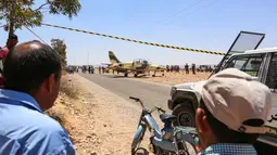 Warga melihat kondisi pesawat jet tempur Libya L-39 Albatros pasukan Khalifa Haftar di Kota Medenine di perbatasan Tunisia-Libya (22/7/2019). Pendaratan darurat jet tersebut sampai mengundang banyak perhatian warga di Kota Medenine. (AFP Photo/Fathi Nasri)