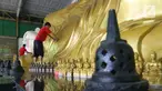 Pekerja membersihkan patung Buddha Tidur di Vihara Buddha Dharma dan 8 Pho Sat, Desa Tonjong, Tajurhalang, Bogor, Selasa (25/5/2021). Vihara itu mulai dihias dan dibersihkan untuk memberi kenyamanan bagi umat Budha yang akan beribadah saat peringatan Hari Raya Waisak. (Liputan6.com/Herman Zakharia)
