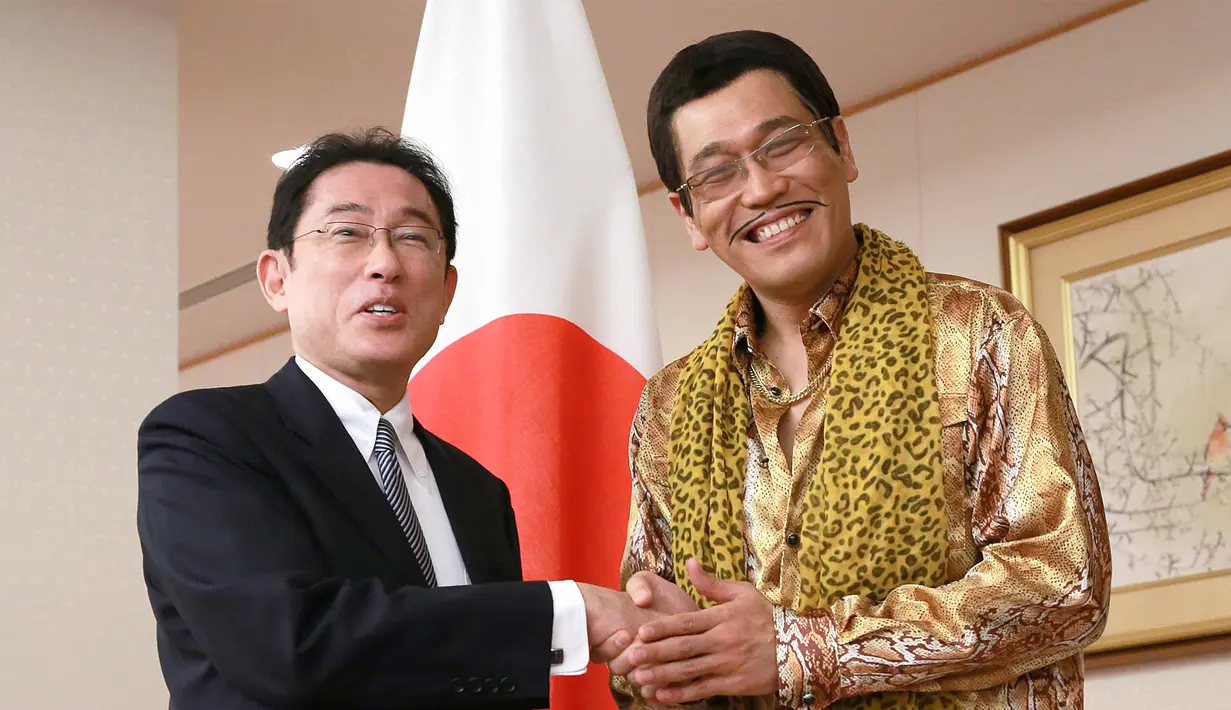 Komedian Jepang Pikotaro berjabat tangan dengan Menteri Luar Negeri Jepang Fumio Kishida di Kementerian, Tokyo, Rabu (12/7). Pikotaro diundang untuk mendampingi Menlu ke pertemuan PBB di markas besar, New York. (AP/ Eugene Hoshiko)