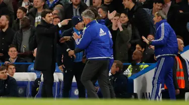 Pelatih Chelsea, Guus Hiddink berusaha menenangkan pelatih Tottenham, Mauricio Pochettino saat pertandingan di Stadion Stamford Bridge, Inggris (3/5). Chelsea bermain imbang dengan Tottenham dengan skor 2-2. (Reuters/John Sibley)