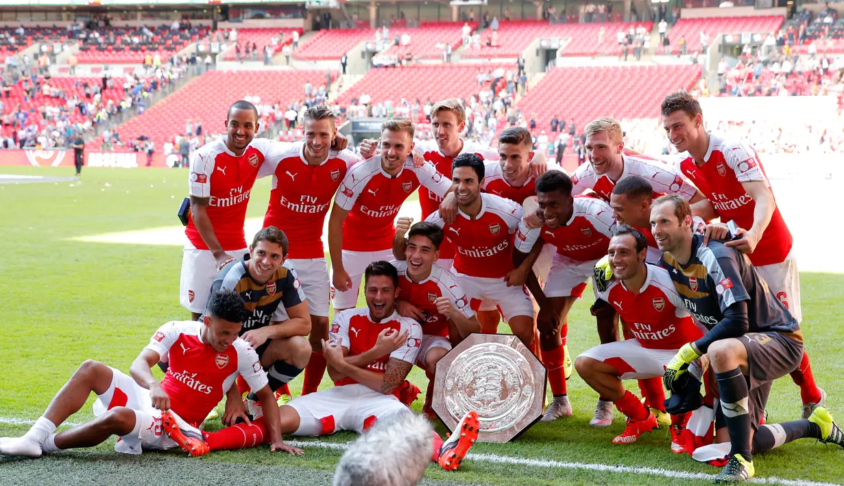 Pemain Arsenal berfoto bersama dengan trofi merayakan kemenangan usai mengalahkan Chelsea pada FA Community Shield di Wembley Stadium, Minggu (2/8/2015). Arsenal menang atas Chelsea dengan skor 1-0. (Reuters/Andrew Couldridge)
